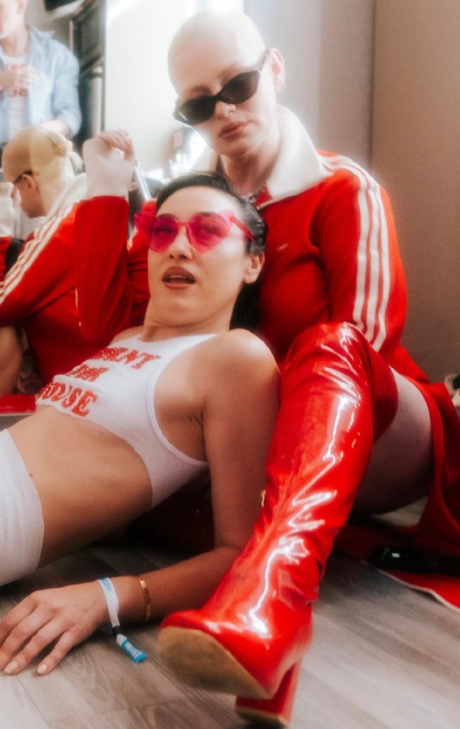 DJ Mia Moretti in heart-shaped sunglasses and red boots with Uffie backstage at OUTLOUD Music Festival during WeHo Pride