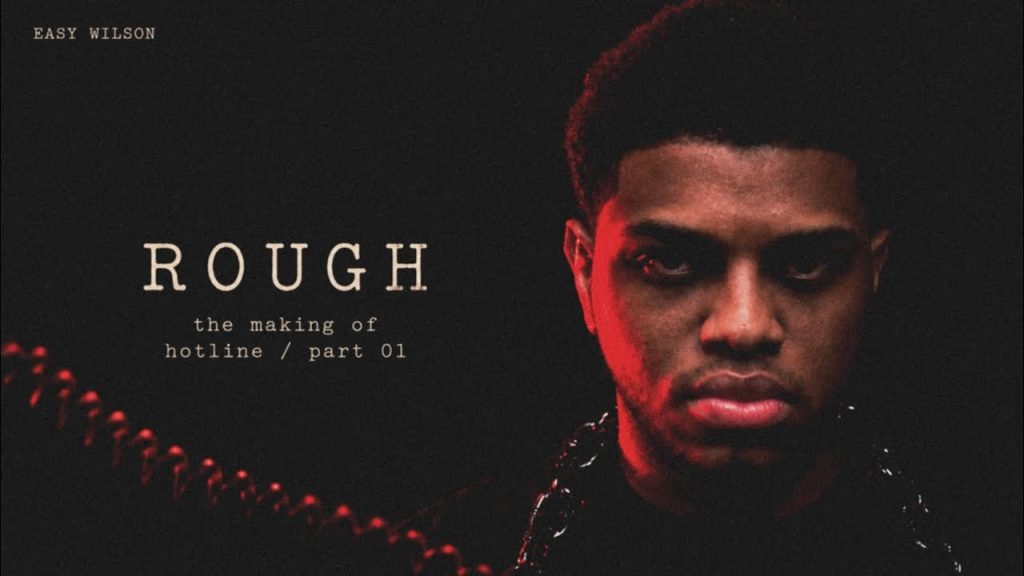 Easy Wilson lit in red with chains for the making of his single Rough