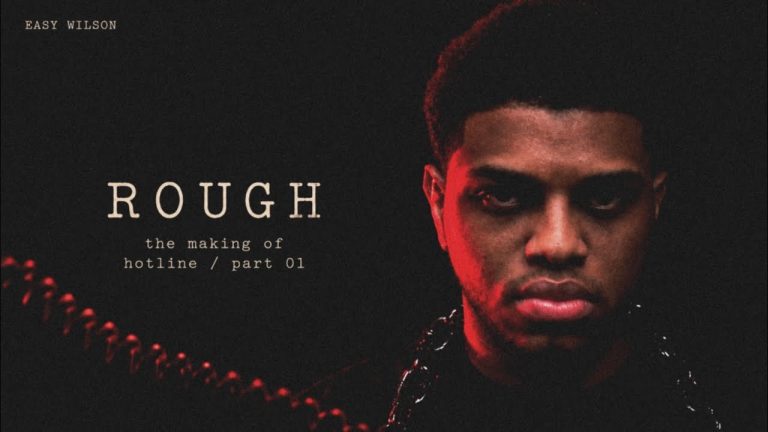 Easy Wilson lit in red with chains for the making of his single Rough