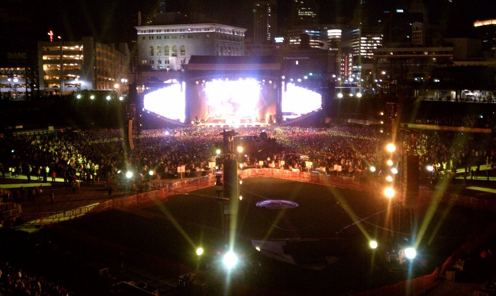 Night view of a packed Comerica Park in Detroit during the Eminem and Jay-Z concert, stage lights glowing