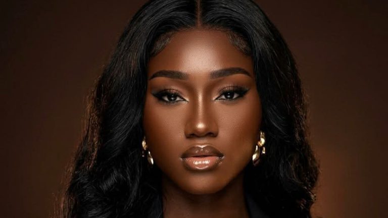 Jessygirl, Haitian-American singer, in a close-up portrait with long dark hair and gold earrings