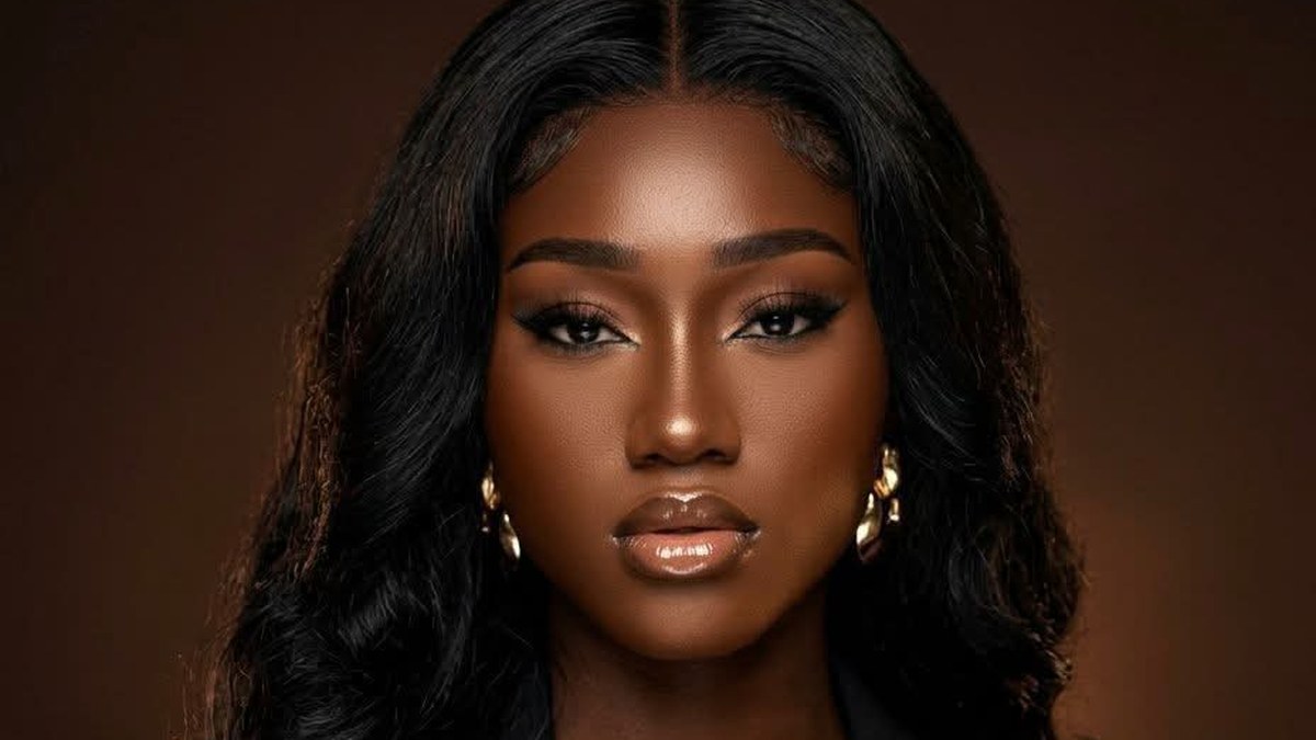Jessygirl, Haitian-American singer, in a close-up portrait with long dark hair and gold earrings