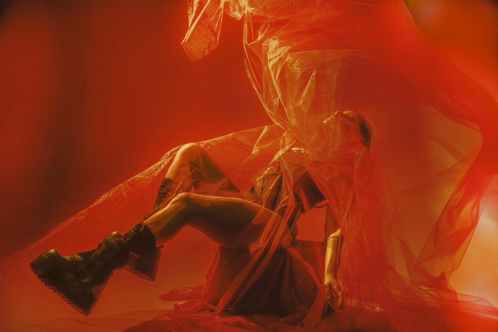 Amakiya mid-movement draped in sheer orange fabric