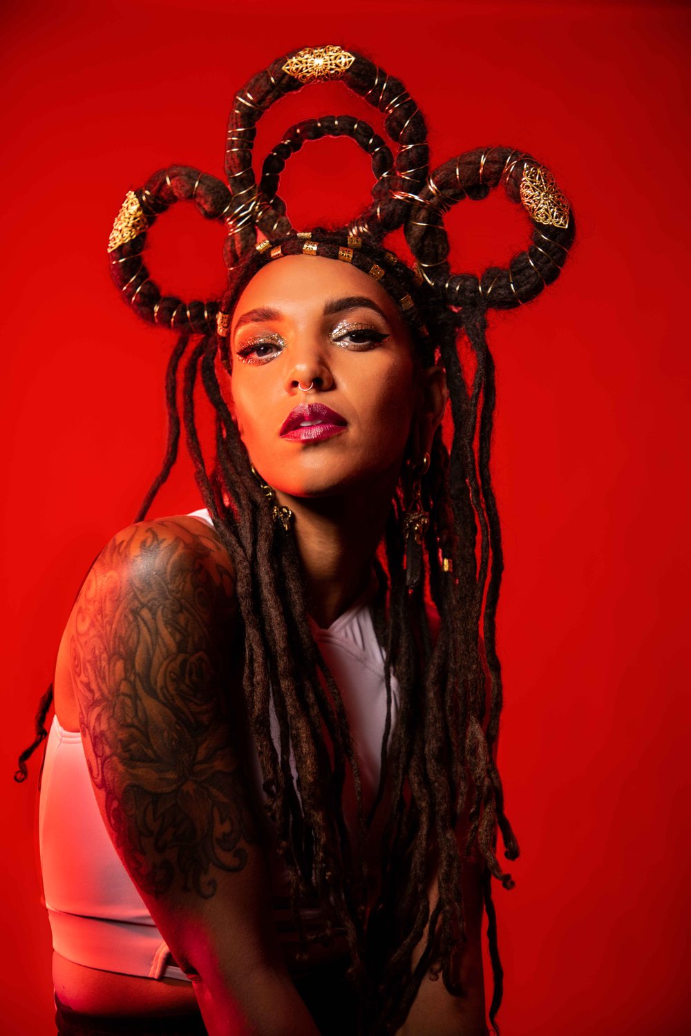 Amakiya portrait in a gold-trimmed crown against a red backdrop