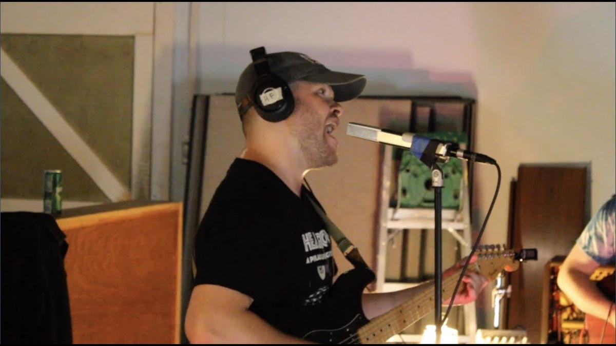 Andrew Huston singing and playing guitar with his band during a Cart Sessions recording