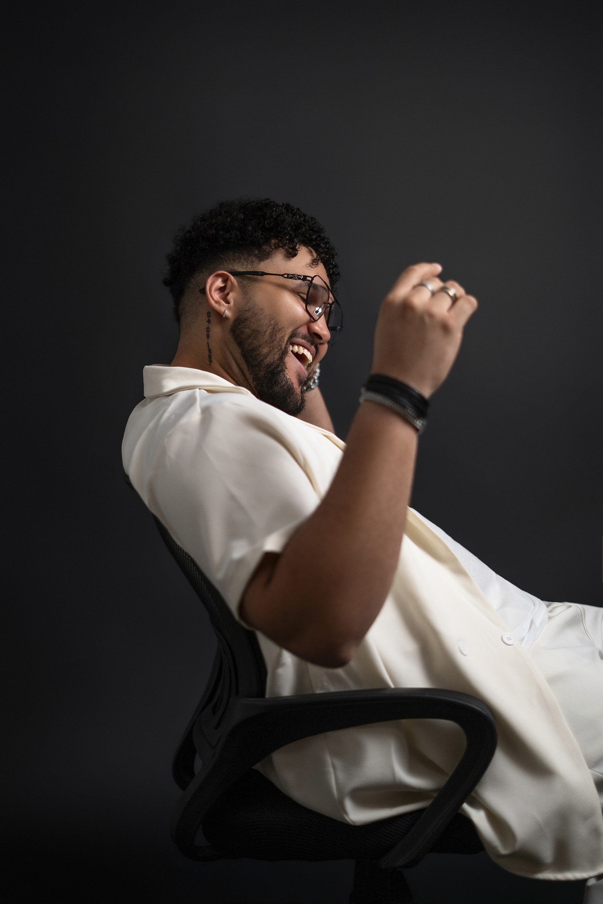 ARAM, Dominican artist and producer, seated in a studio portrait