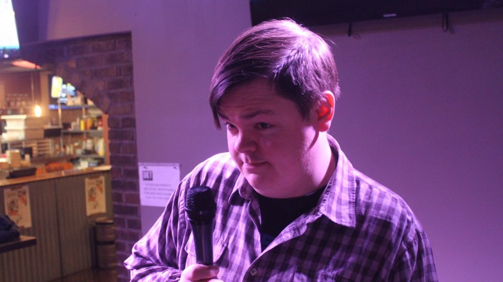 A comedian holding a microphone at a stand-up comedy show