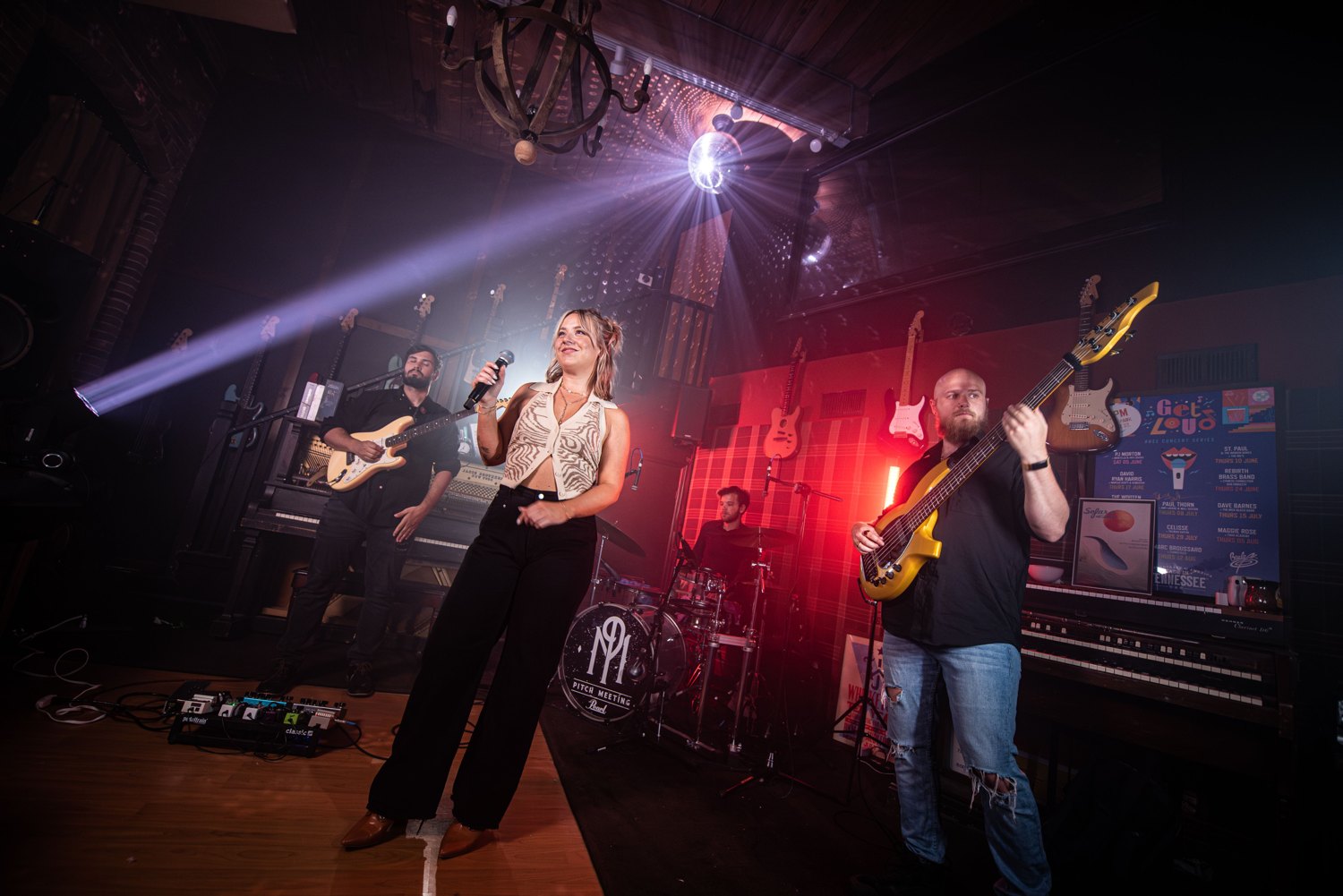 Dani Stacy singing on stage with her band under stage lights