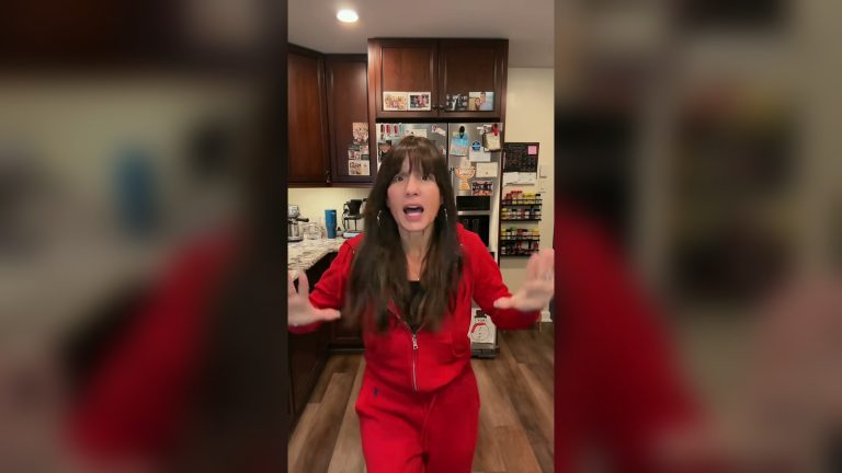 Devon Vander in a red tracksuit rapping along to Eminem in her kitchen