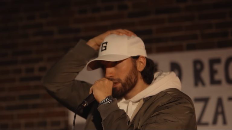 Gawne rapping into a microphone in a white G cap in the CHOPPER music video
