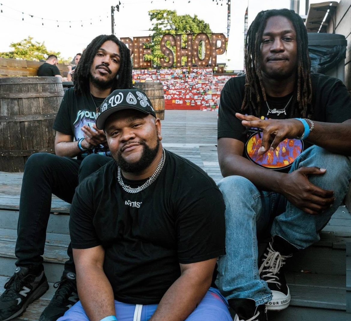 HUE band members Alireza, Arejay James and Nic Keene sitting on steps in Washington DC