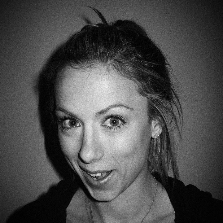 Black-and-white close-up portrait of comedian Iliza Shlesinger making a playful face in 2012