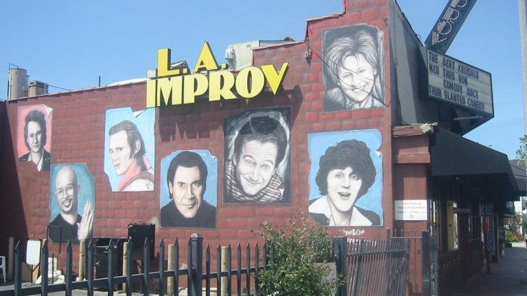 The Improv comedy club on Melrose Avenue with painted portraits of comedians on its brick wall