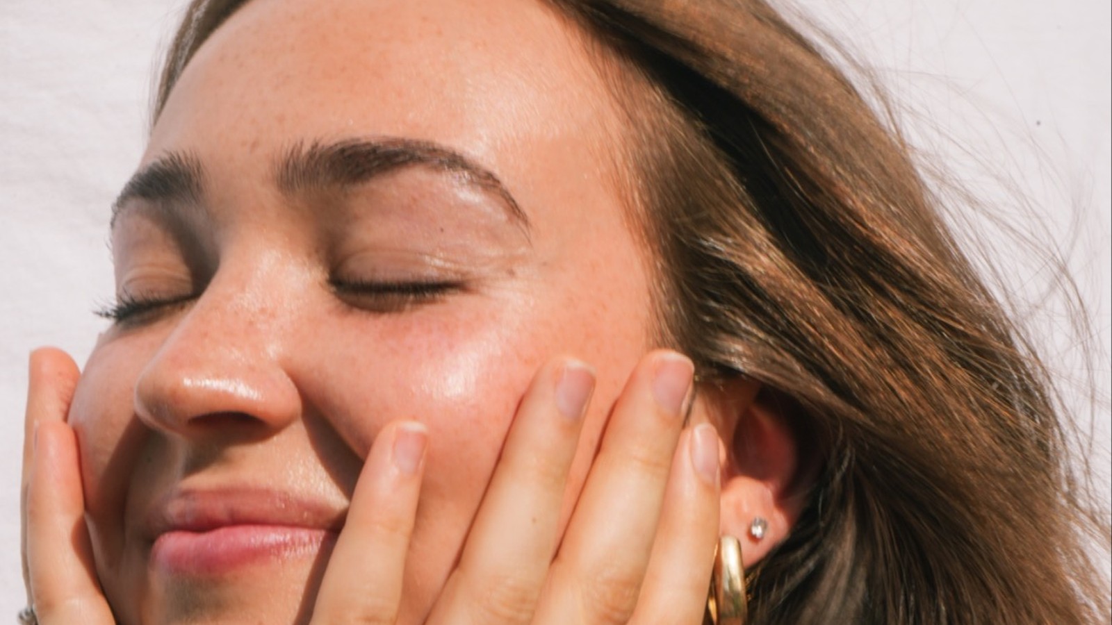 Kaitlyn Danos, Christian pop singer-songwriter, smiling with her eyes closed in the sun