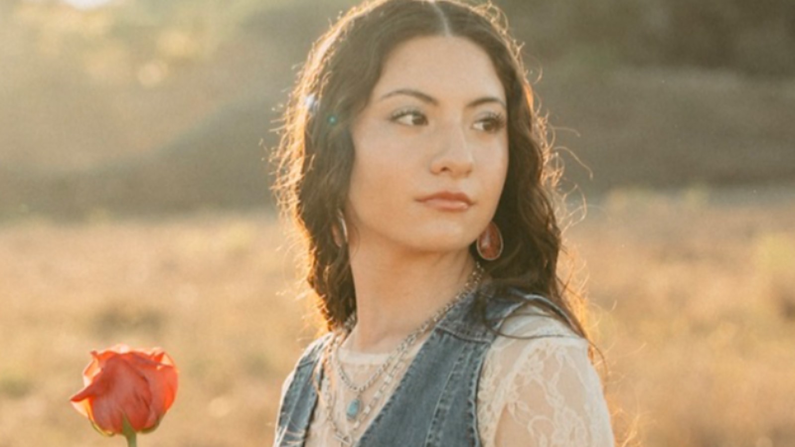 Lilly Amaris, Christian singer-songwriter, holding a red rose in a golden field