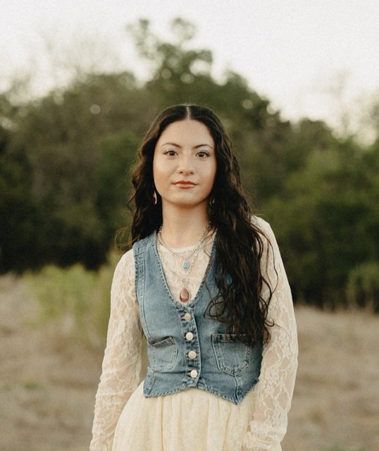 Lilly Amaris in a denim vest and lace dress outdoors