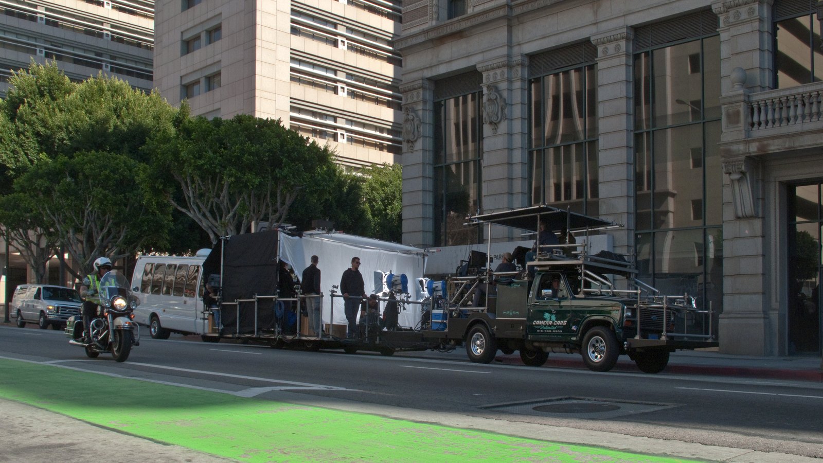 A film crew on location on Spring Street in downtown Los Angeles with a camera car and lighting rig
