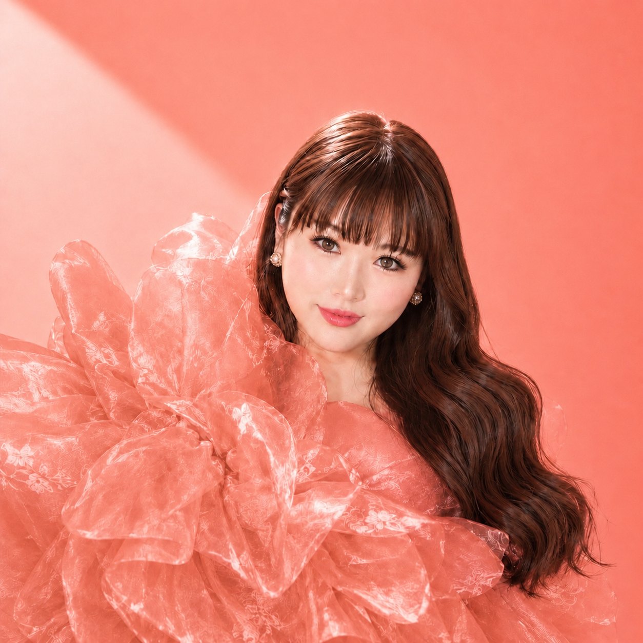LUTILU, Japanese pianist based in Los Angeles, in a coral organza top against a coral backdrop