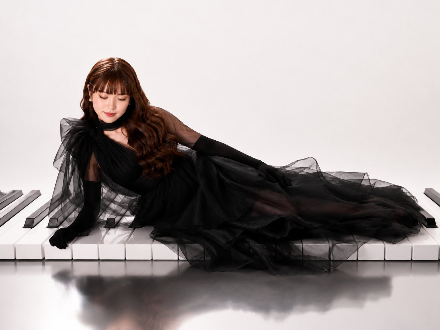 LUTILU in a black tulle gown lying across a row of oversized piano keys