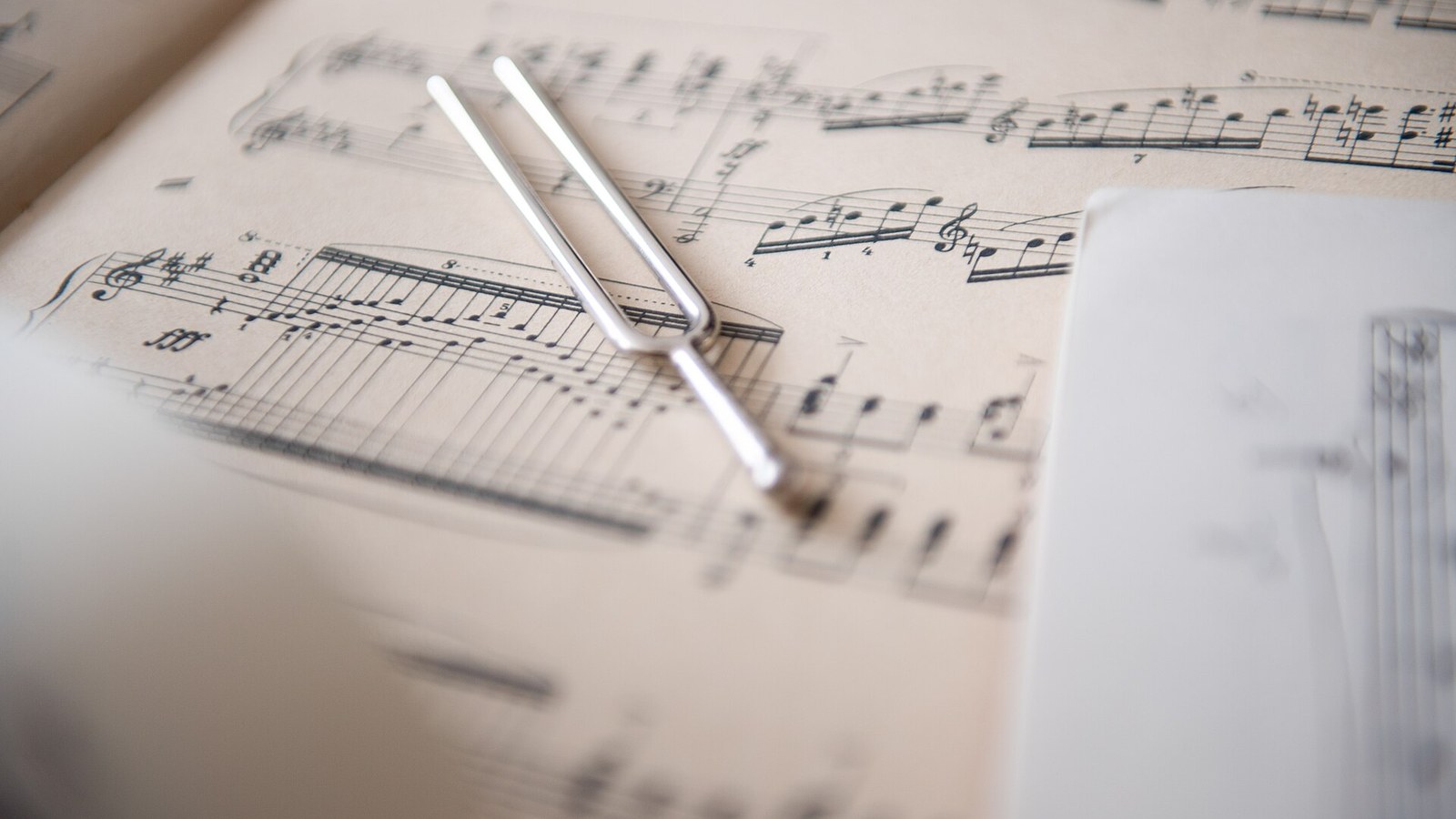 A tuning fork resting on a page of sheet music