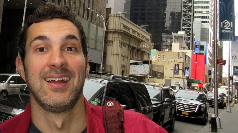 Comedian Mark Normand smiling on a Sixth Avenue sidewalk in Midtown Manhattan, March 2018