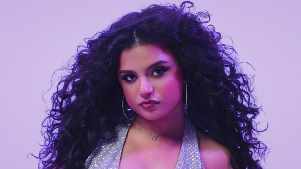 Nikki Nicole, New Jersey pop and R&B singer, with long curly hair against a lavender backdrop