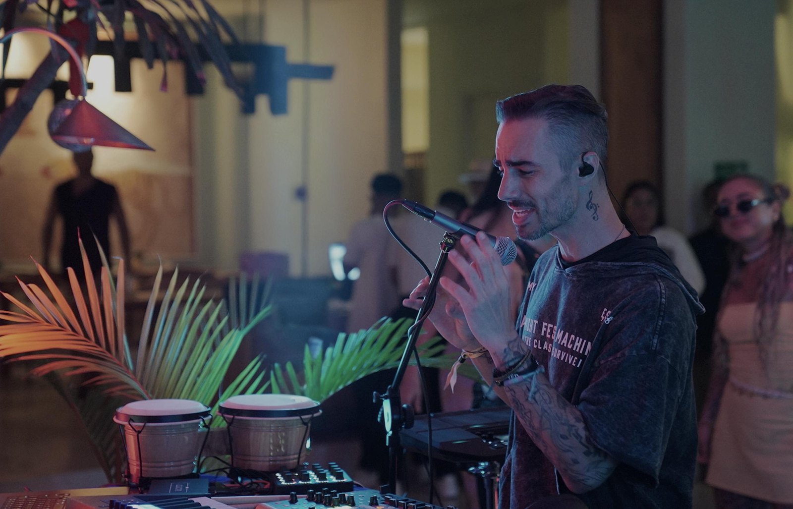 Nova Wolf performing live with a microphone and hand drums