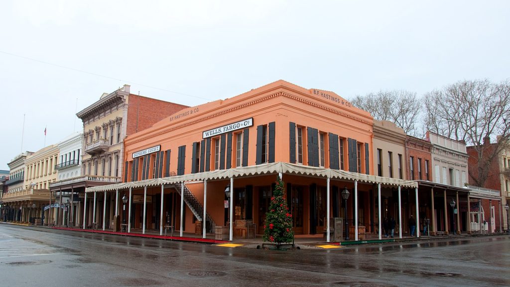Historic storefronts with covered wooden sidewalks in the Old Sacramento Historic District on a rainy day