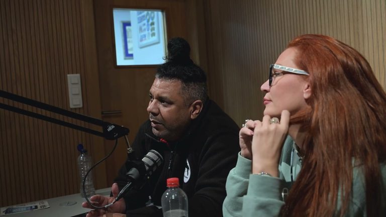 Orlando Leyba talking into a podcast microphone next to comedian April Macie during an Armed Forces Entertainment tour in Belgium, 2026