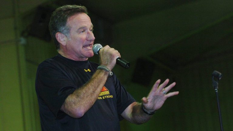 Robin Williams performing stand-up comedy with a microphone for U.S. troops