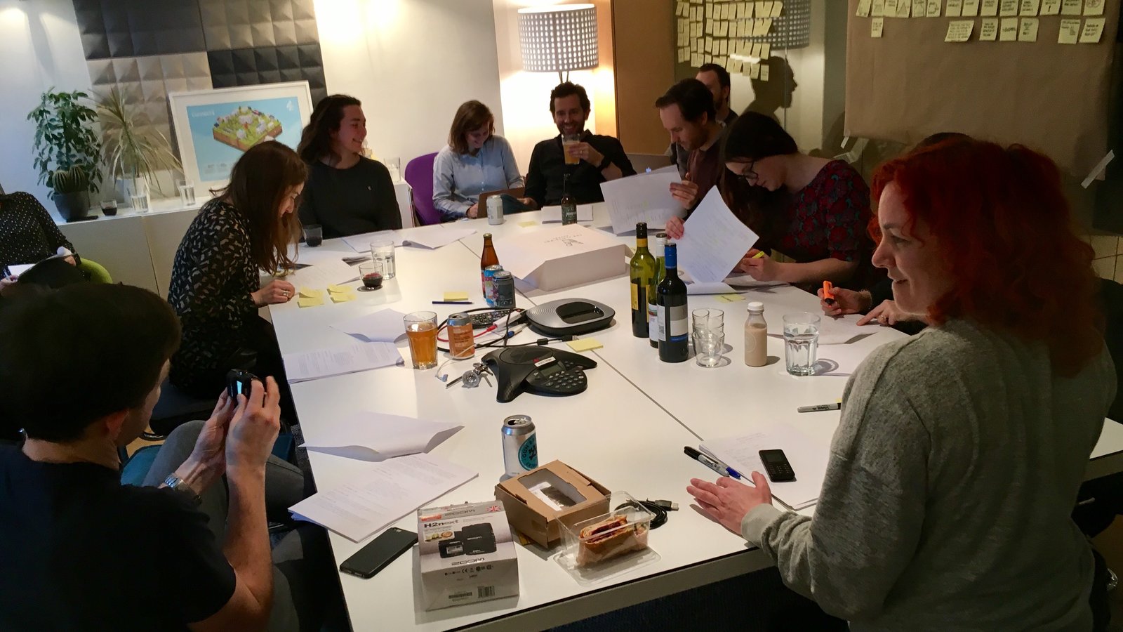 Writers and actors sitting around a table during a table read of a sitcom pilot
