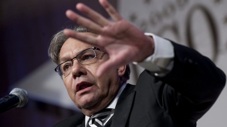 Comedian Lewis Black gesturing at the microphone during a stand-up set