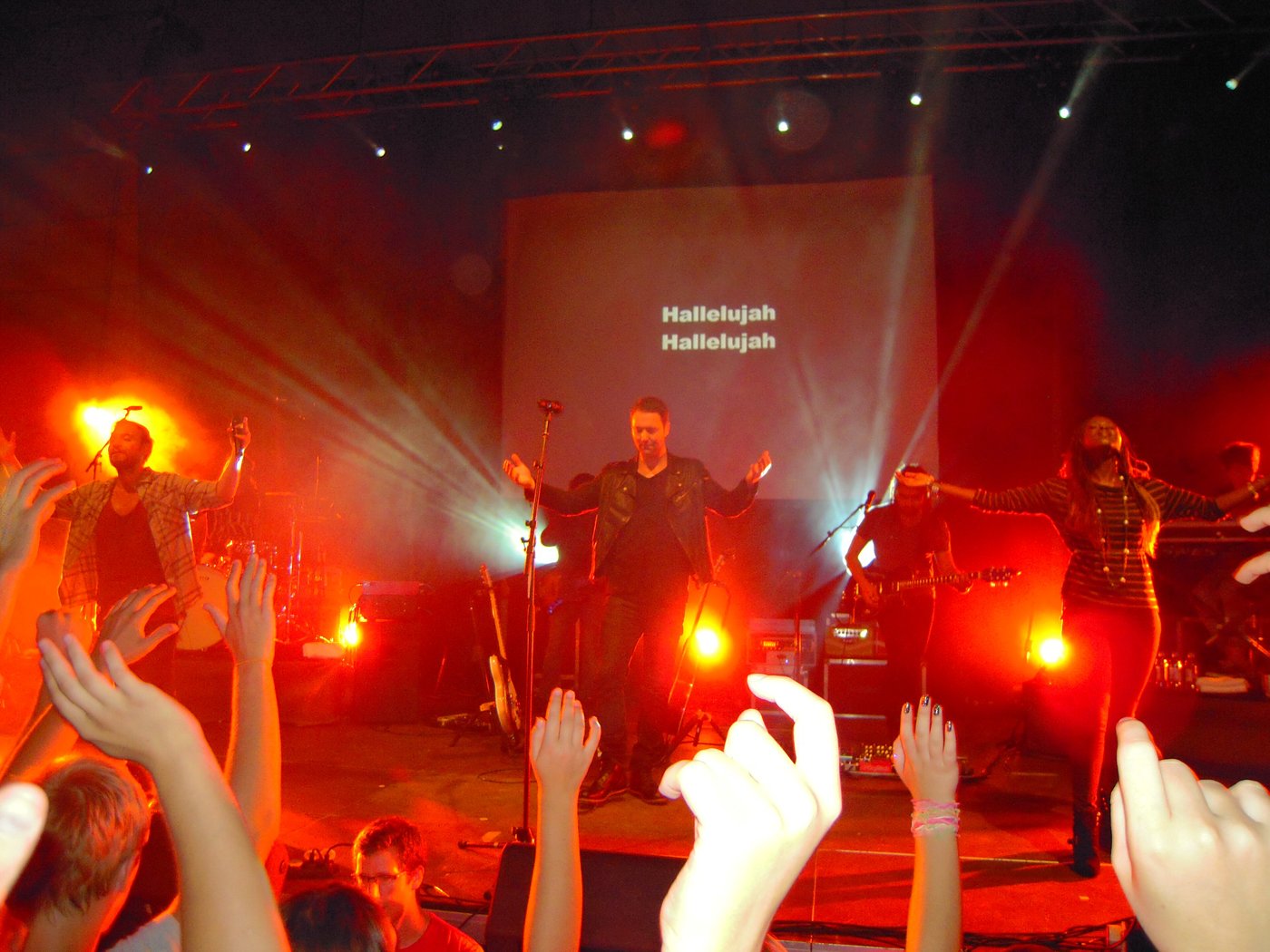 Concertgoers raising their hands during a worship song